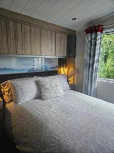 a bedroom with a bed and a large window at 22 Bryn View - Davies Retreat in Prestatyn