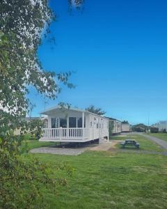 a white house with a picnic table in the grass at 22 Bryn View - Davies Retreat in Prestatyn