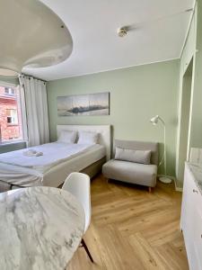 a bedroom with a bed and a chair and a table at Jade's Suite, Helsinki Center in Helsinki