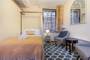 a bedroom with a bed and a chair and a window at The Merchants House in Hereford
