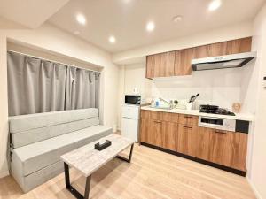 eine kleine Apartment-Küche mit einem Sofa und einem Tisch in der Unterkunft Shinjuku 歌舞伎町E3 in Tokio