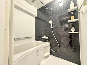 ein Badezimmer mit Dusche und Badewanne in der Unterkunft Shinjuku 歌舞伎町E3 in Tokio