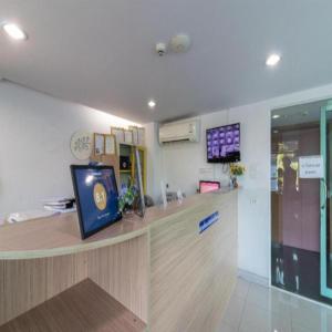 a waiting room with a counter with a tv on the wall at Collection O Siam Privi Hotel in Bangkok