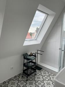 a bathroom with a skylight and a toilet and a chair at Elegantes Apartment in Villa in Ottobeuren