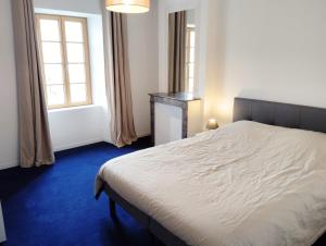 a bedroom with a white bed and a window at Gîte de l'Église de la Pommeraie in La Pommeraie-sur-Sèvre