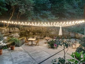 eine Terrasse mit Tischen, Stühlen und Lichtern in der Unterkunft Innwoods Hotel Alaverdi in Alawerdi