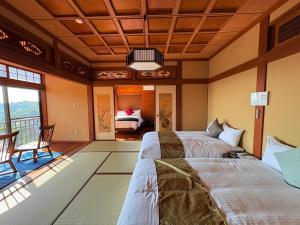 une chambre avec deux lits dans une pièce dans l'établissement Beppu Kura, à Beppu