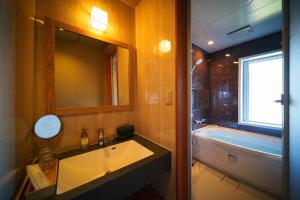 une salle de bain avec une baignoire et un lavabo et une baignoire dans l'établissement Beppu Kura, à Beppu 31 autres photos