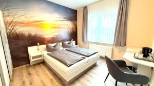 a bedroom with a bed with a painting on the wall at Kastanienhof Hotel garni in Zinnowitz