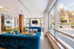a lobby with blue furniture and a view of a city at Eurostars Lucentum in Alicante