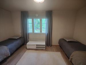 a bedroom with two beds and a window at Kodikas talo lammen rannalla in Raahe