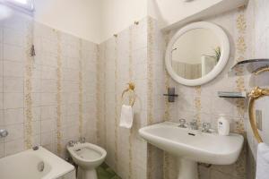 ein Badezimmer mit Waschbecken, Toilette und Spiegel in der Unterkunft Santa Croce in Florenz + 28 Fotos