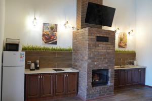 a kitchen with a brick fireplace and a tv at The Selo in Korostovat