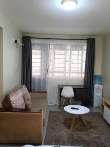 a living room with a couch and a table at Comfy Studio in Ngong