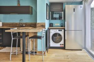 a kitchen with a refrigerator and a washing machine at Appartement cozy proche de la plage in Brétignolles-sur-Mer