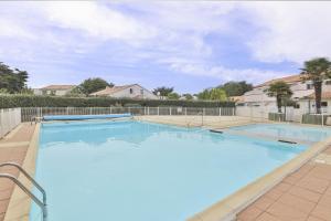 a large swimming pool with blue water at Appartement cozy proche de la plage in Brétignolles-sur-Mer