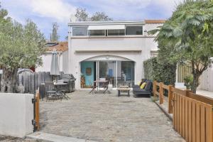 a white house with a patio in front of it at Appartement cozy proche de la plage in Brétignolles-sur-Mer