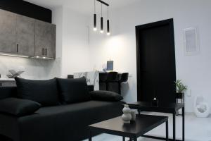 a living room with a black couch and a table at Easy Wave Premium Suites in Pylos