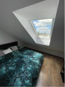 Habitación en el ático con cama y ventana en VISTA Necko, en Augustów