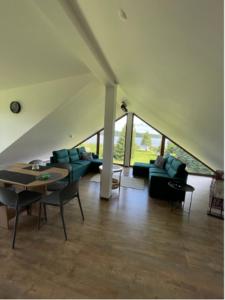 Una sala de estar con sofás y una mesa y sillas. en VISTA Necko, en Augustów