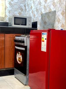 a kitchen with a red stove and a microwave at Sun city One bedroom Apt in Kampala +8 photos