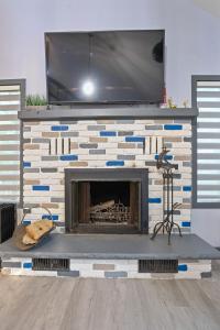 un camino in mattoni con una TV sopra di Vacation Home w Game Room Sauna Hot Tub Private Pool a East Stroudsburg