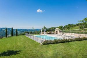 a swimming pool in a yard with a grass field at Casa Emanuela in Fermignano