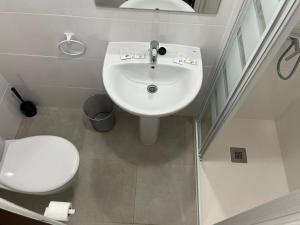 a bathroom with a white sink and a toilet at El encuentro in El Barraco