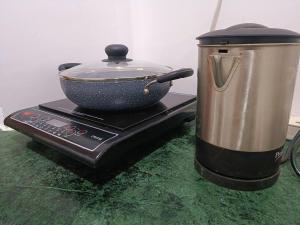 a pot and a pan on top of a stove at Cozy and Tranquil nest with wifi and homely care in Greater Noida