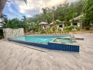 a swimming pool with blue tile around a house at Krabi Inn Resort in Ao Nam Mao