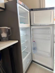 una nevera abierta con una botella de agua. en Attico Vista Mare, en Lido di Jesolo
