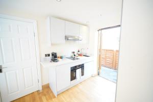 a white kitchen with a sink and a stove at Stylish Stratford upon Avon Stay - Gated Parking - Sleeps 6 in Stratford-upon-Avon