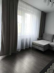 a living room with a couch and a window at Alma Apartments Starachowice in Starachowice