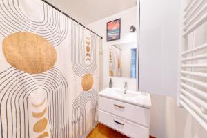 un baño con lavabo y espejo en Appartement cosy parking privé, en Saint-Ouen 40 fotos más