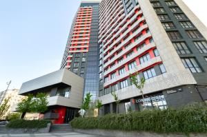 Un edificio alto con una puerta roja delante. en Petrovdom Apartments 20-199a in RC Kvartet, Vasylya Lypkivskoho Street 16Г, en Kiev