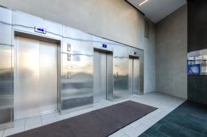 una fila de puertas de ascensor en un edificio en Petrovdom Apartments 20-199a in RC Kvartet, Vasylya Lypkivskoho Street 16Г, en Kiev