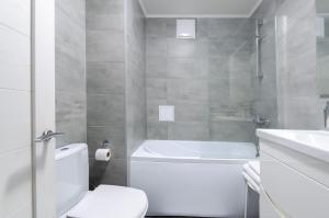 Un baño con bañera, inodoro y lavabo. en Petrovdom Apartments 20-199a in RC Kvartet, Vasylya Lypkivskoho Street 16Г, en Kiev 30 fotos más