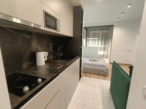 eine Küche mit Spüle und ein Bett in einem Zimmer in der Unterkunft ЖК Аржанова in Dnipro + 66 Fotos