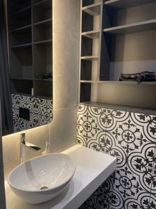 ein Badezimmer mit einem weißen Waschbecken und einem Spiegel in der Unterkunft ЖК Аржанова in Dnipro