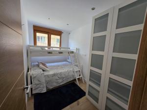 Una pequeña habitación con una litera y una ventana. en La casa de Teresa, en Santiago de Compostela