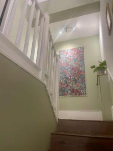 a staircase with a painting on the wall at Bridge House in Broadwater