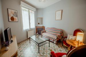 a living room with a couch and a table at Maison clim 3 ch Bord du Tarn Cours extérieure in Moissac