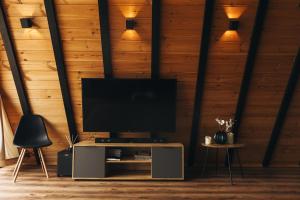 a living room with a television on a wooden wall at Dravis Event Park 