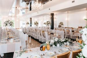 a banquet hall with white tables and chairs at Hotel Campari in Góra Motyczna