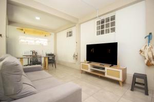 a living room with a couch and a flat screen tv at Refugio na Praia da Vila- Imbituba in Imbituba