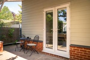 un patio con sillas y mesas en una casa en Garden Villa, en Cambridge 41 fotos más
