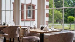 a dining room with a table and chairs and windows at Landhotel Sophienhöhe in Kerpen +16 photos