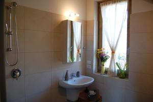 a bathroom with a sink and a mirror and a window at Agriturismo Casa del Castagneto in Gargnano +43 photos
