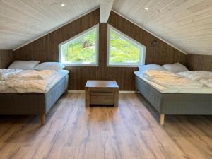 two beds in a room with two windows at New cabin Vrådal - sunny - fantastic hiking areas in Kviteseid