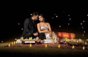 a man and a woman sitting on a blanket with candles at Rajputana Desert Camp in Jaisalmer